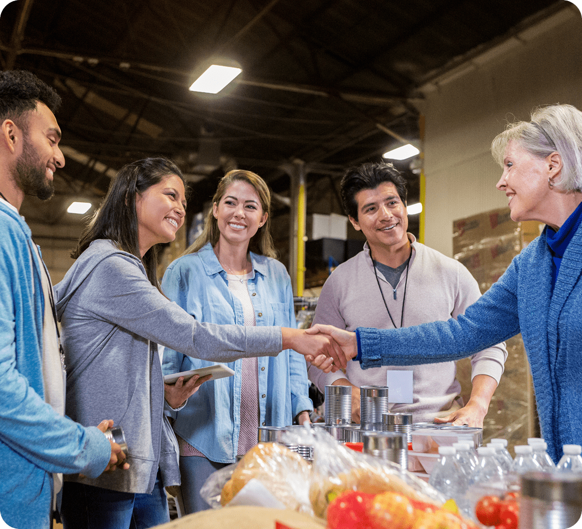 Smiling volunteers handling food donations.